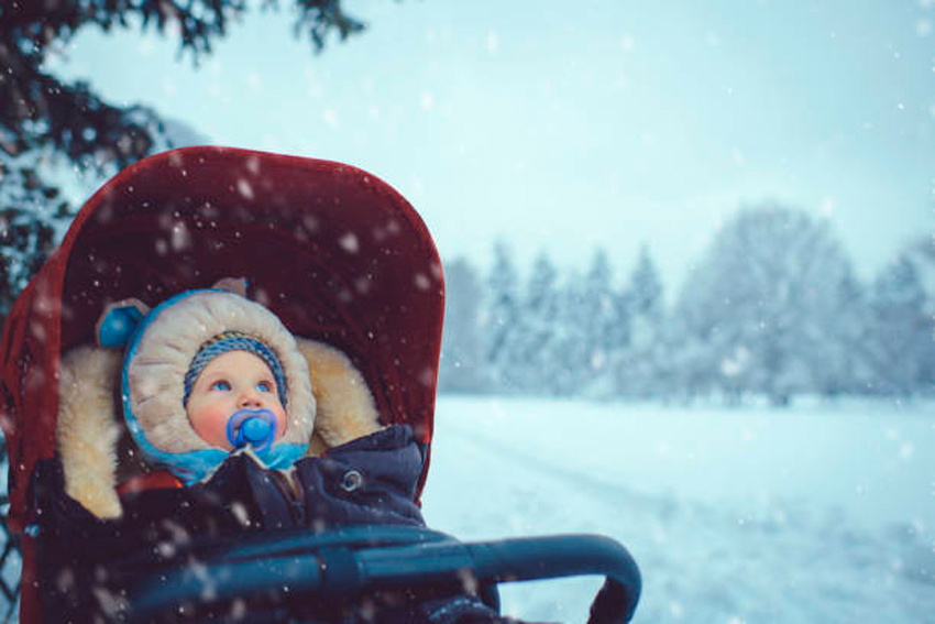 bebé en su carrito en la nieve