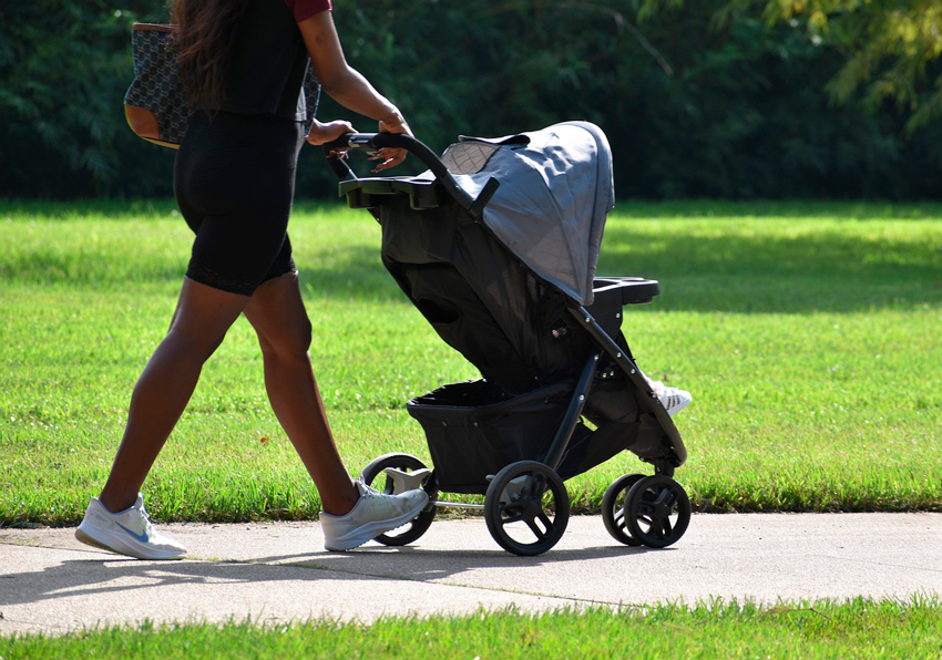 madre e hijo paseando con el cochecito por el parque