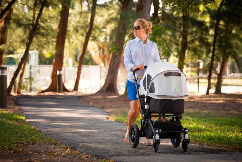 mujer paseando a su bebé por el parque